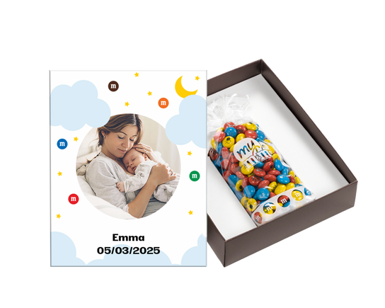 een verjaardagsbox, opgemaakt met een foto van een glimlachende persoon op de voorkant. de doos is open gepositioneerd, er in ligt een zakje kleurrijk versierde m&m's 